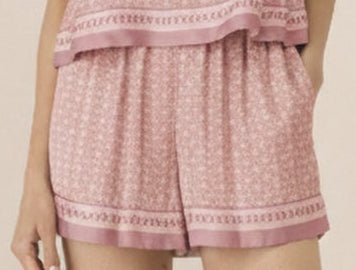 Woman wearing a pink checkered outfit on a beige background Calling June
