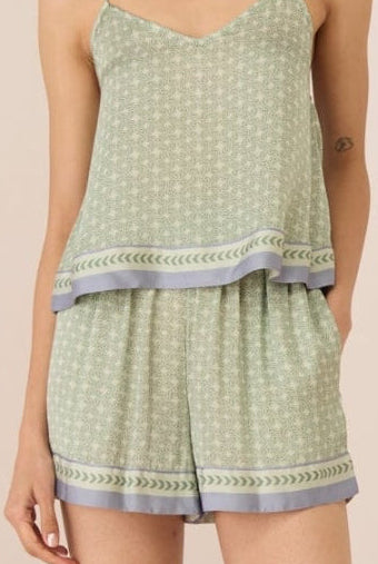 Woman wearing a light green patterned romper on a beige background Calling June