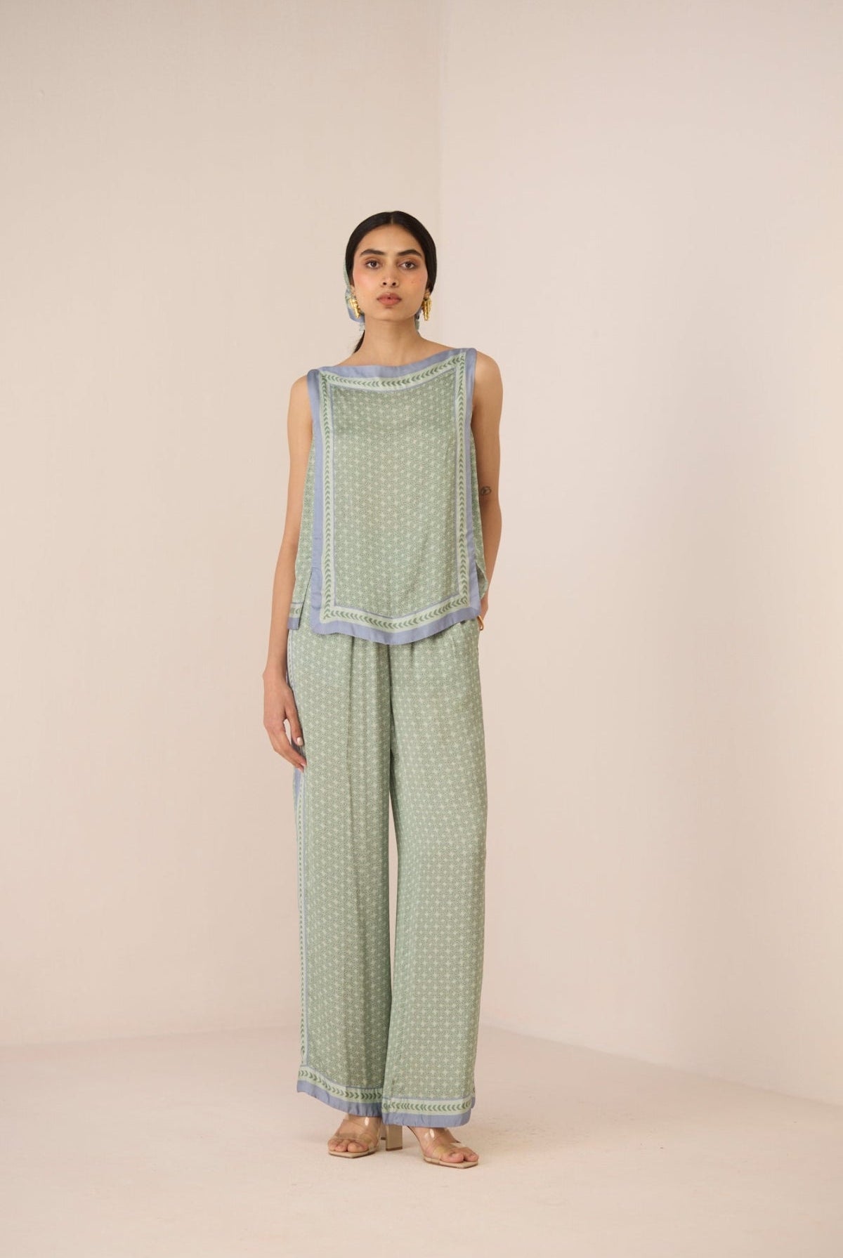 Woman wearing a green patterned outfit on a beige background Calling June