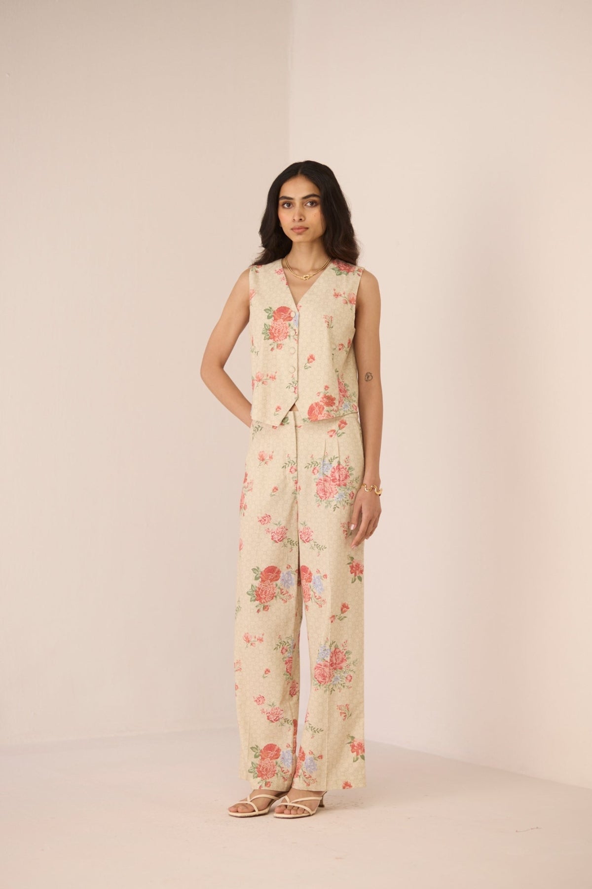 Woman wearing a floral jumpsuit on a plain background Calling June