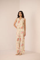 Woman wearing a floral jumpsuit on a plain background Calling June