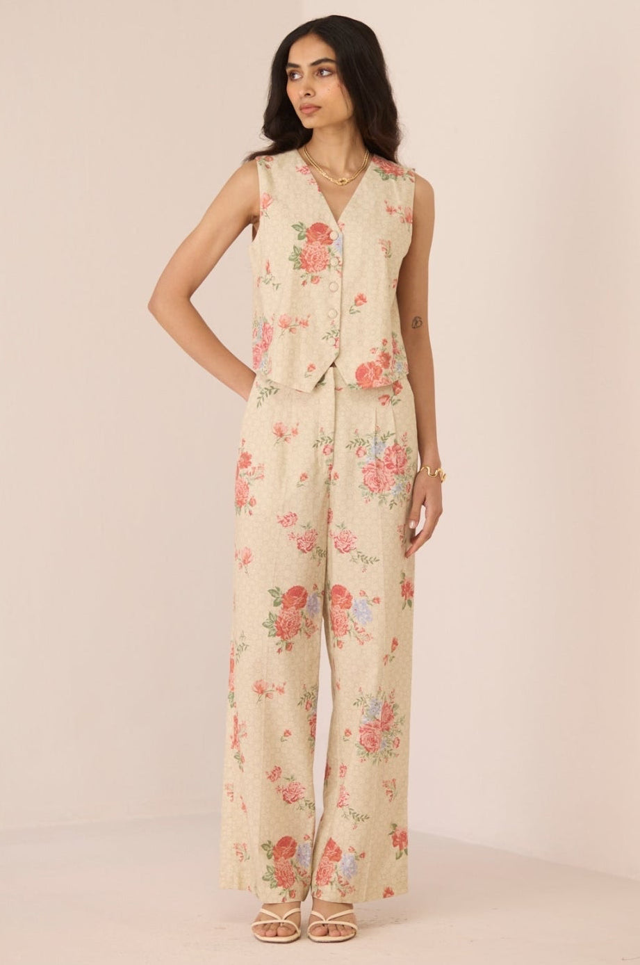 Woman wearing a floral jumpsuit on a plain background Calling June