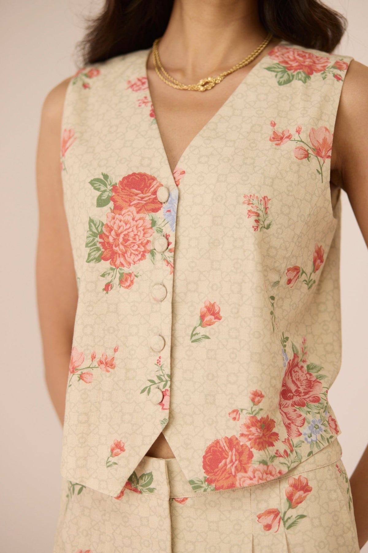 Floral-patterned vest worn by a person on a plain background Calling June