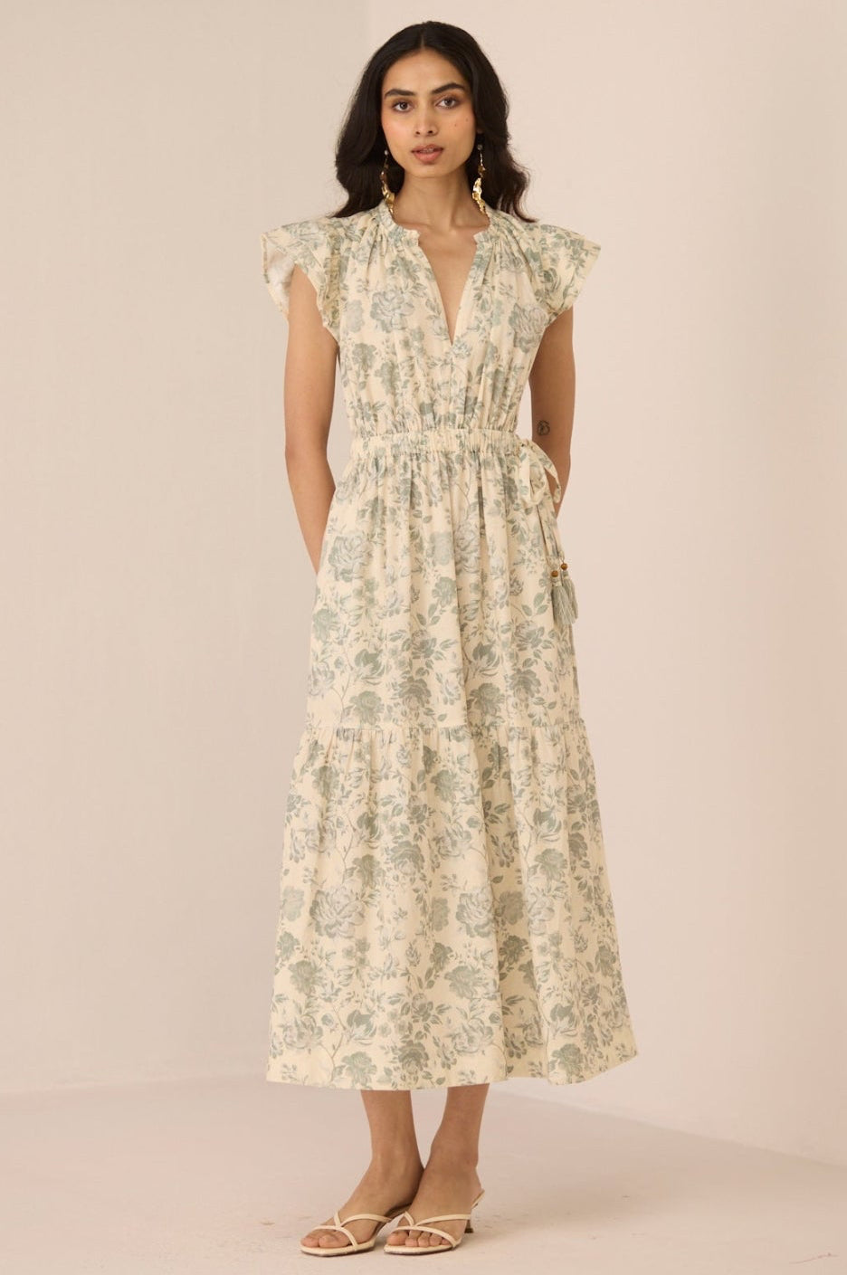 Woman wearing a floral dress against a plain background Calling June