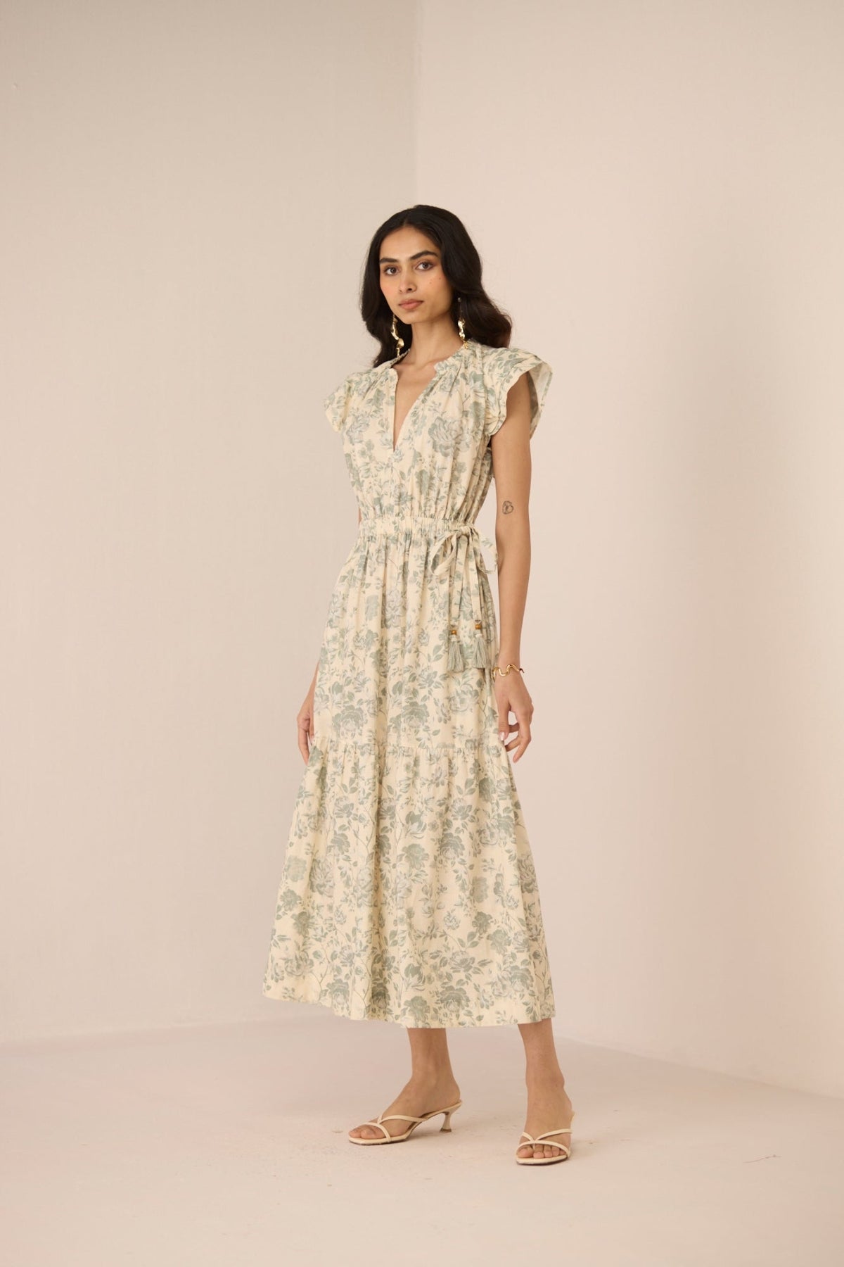 Woman wearing a floral dress against a plain background Calling June