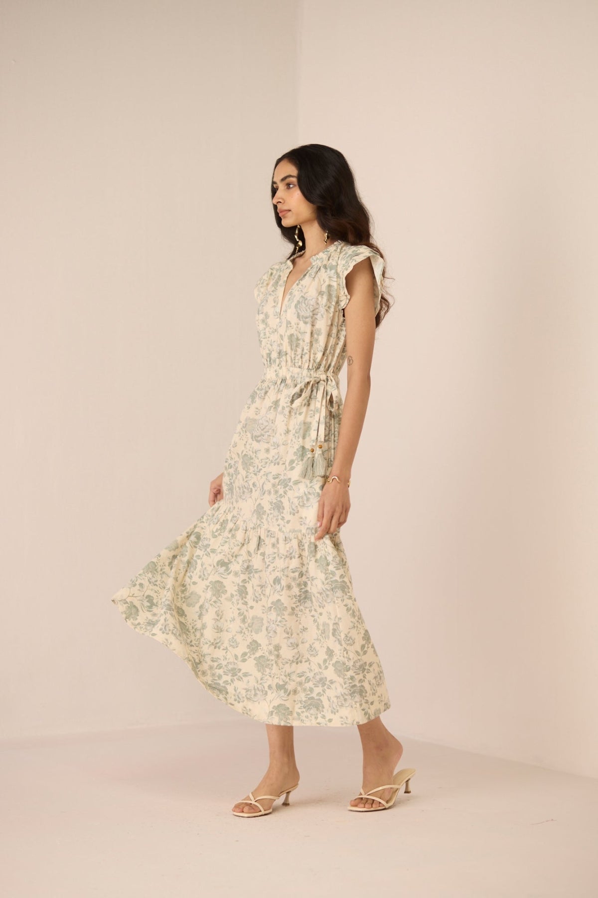 Woman wearing a floral dress on a beige background Calling June