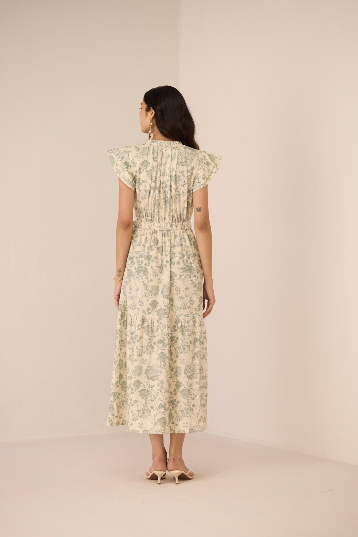 Woman wearing a floral dress against a beige background Calling June