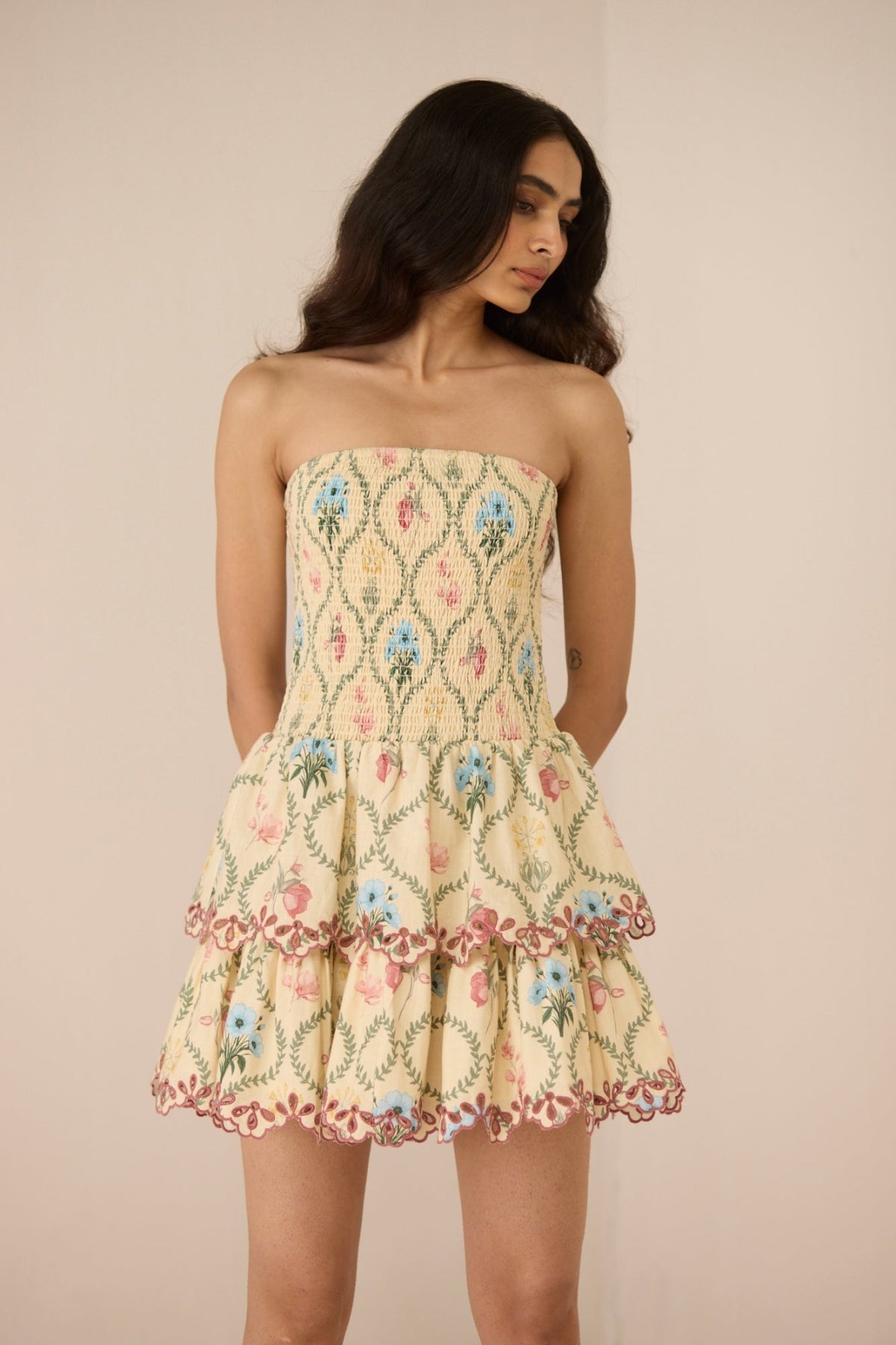 Woman wearing a floral strapless dress against a beige background Calling June