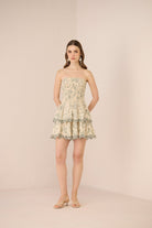 Woman wearing a strapless floral dress on a beige background Calling June