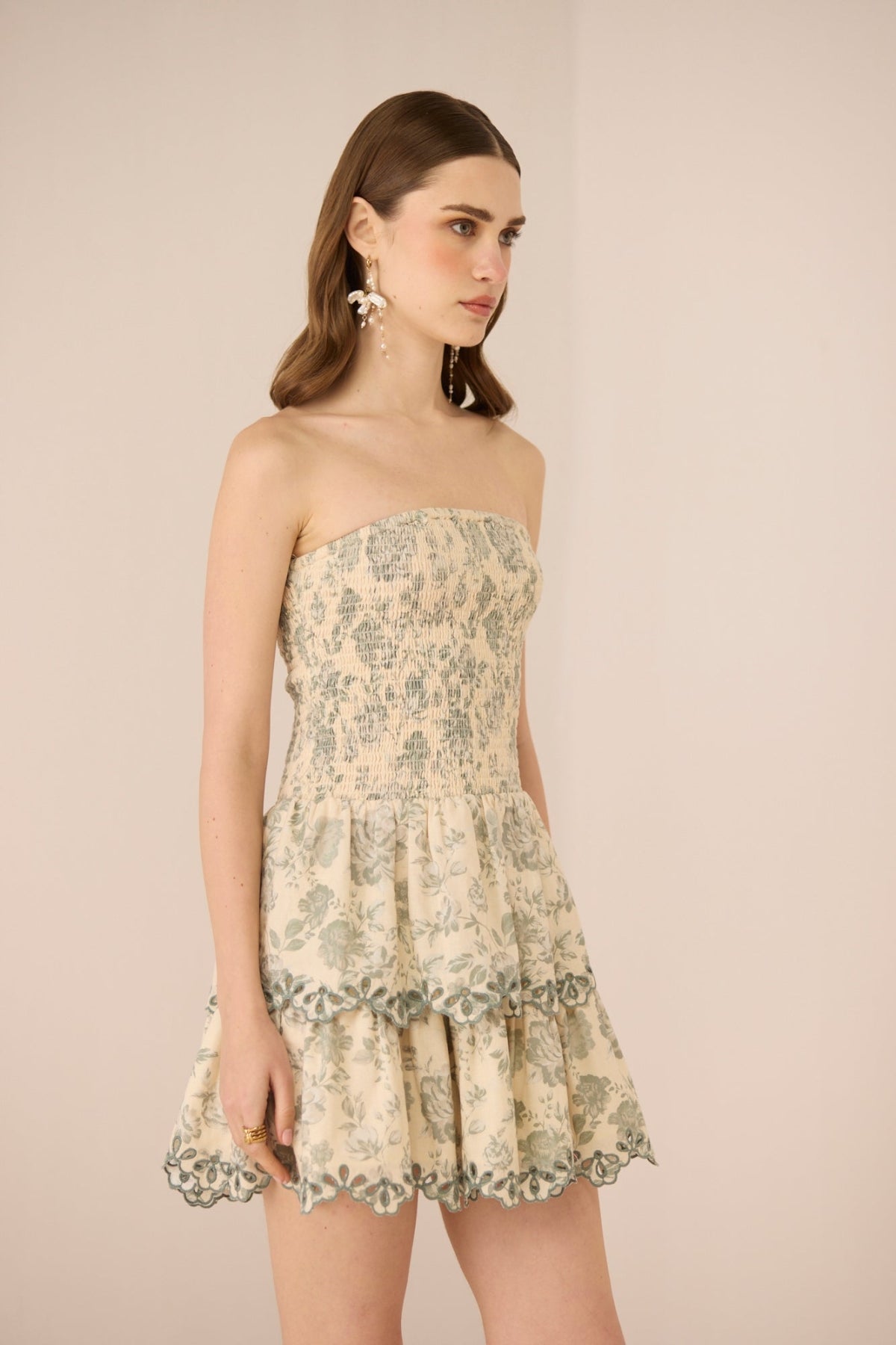 Woman wearing a strapless floral dress against a beige background Calling June