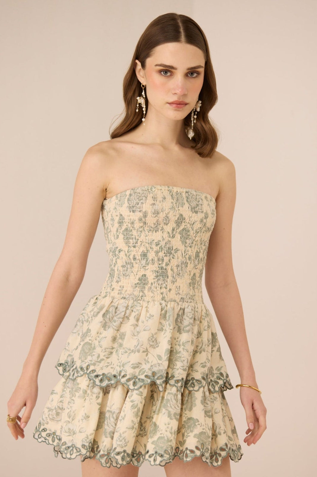 Woman wearing a strapless floral dress against a beige background Calling June