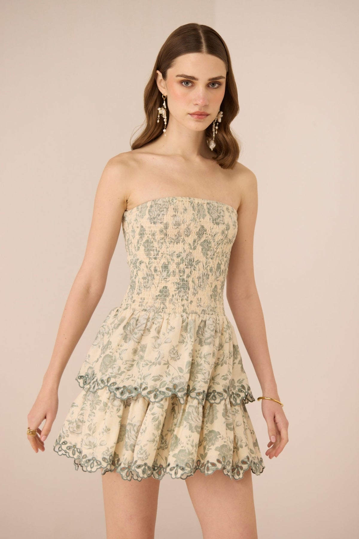 Woman wearing a strapless floral dress against a beige background Calling June