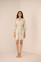 Woman wearing a light-colored dress with a subtle pattern on a beige background Calling June