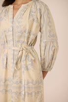 Beige dress with blue pattern on a beige background Calling June