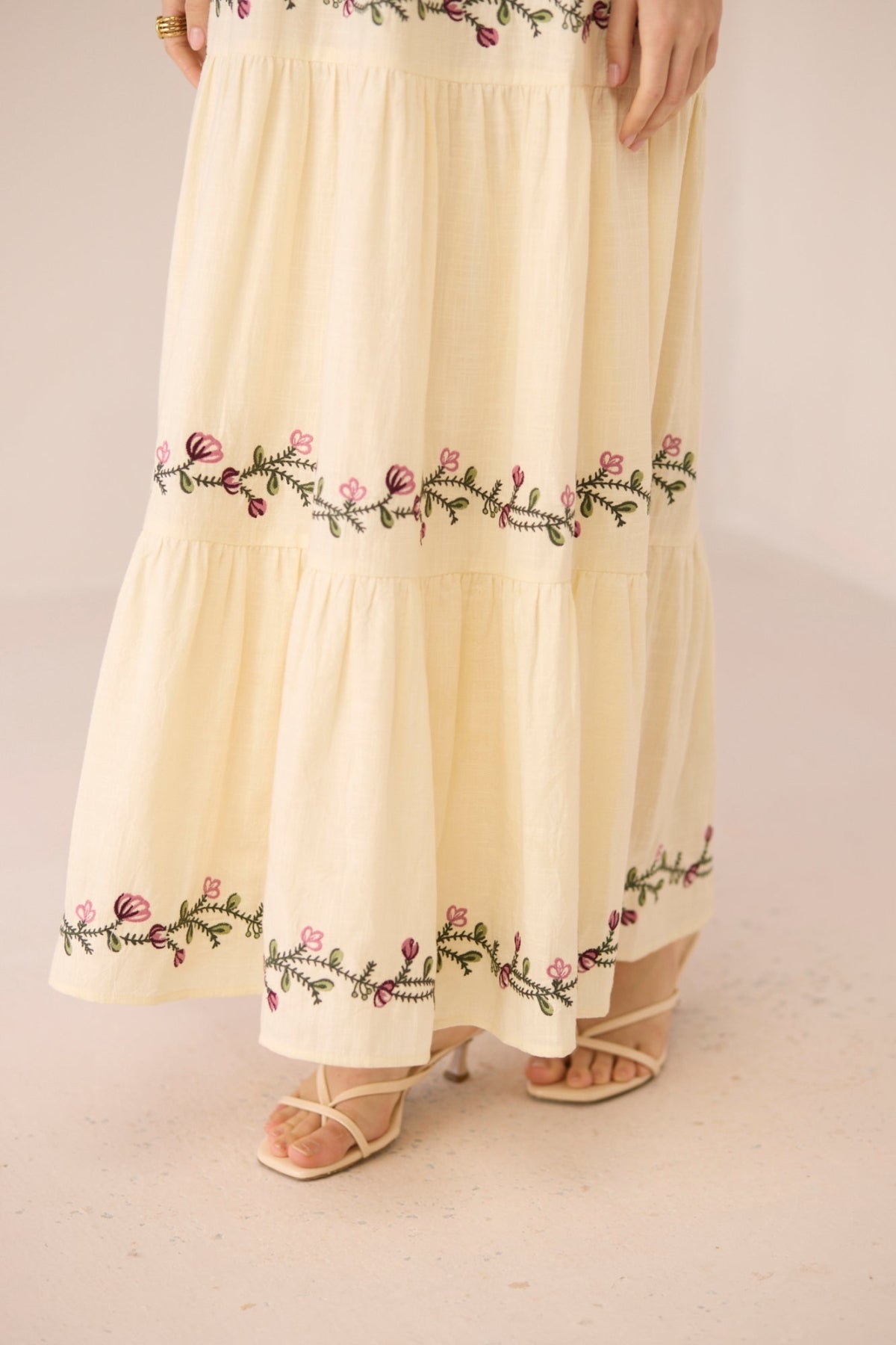 Beige skirt with floral embroidery on a plain background Calling June