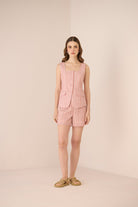 Woman wearing a pink outfit on a beige background Calling June