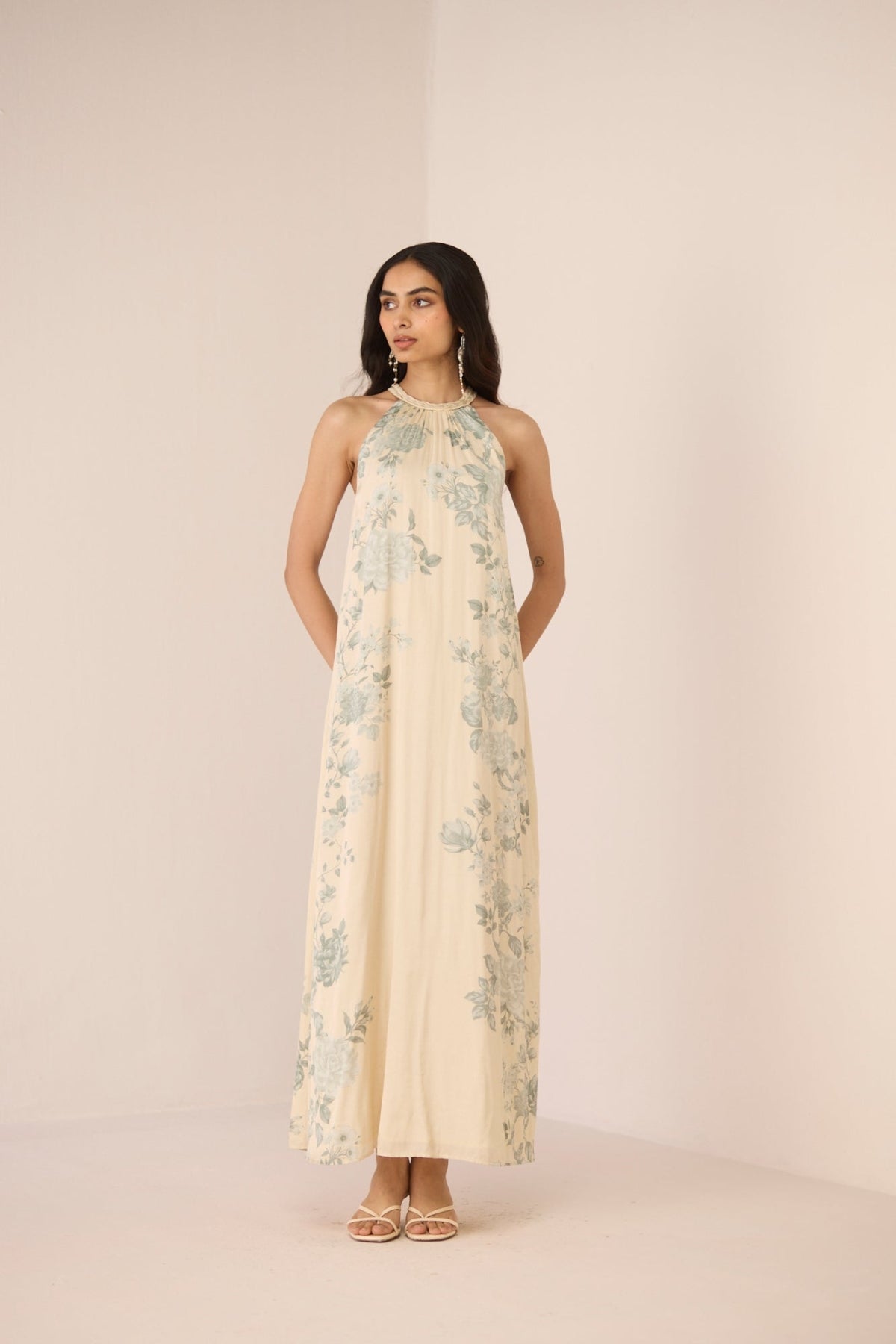 Woman wearing a floral dress against a plain background Calling June