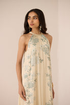 Woman wearing a floral dress against a plain background Calling June