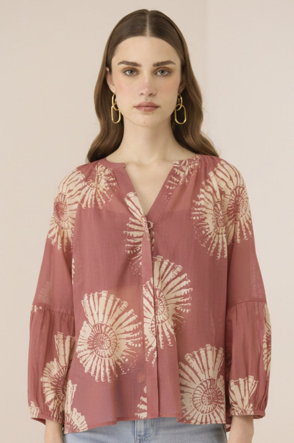 Woman wearing a patterned blouse with a plain background Calling June