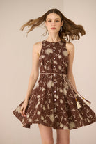 Woman wearing a brown floral dress against a beige background Calling June