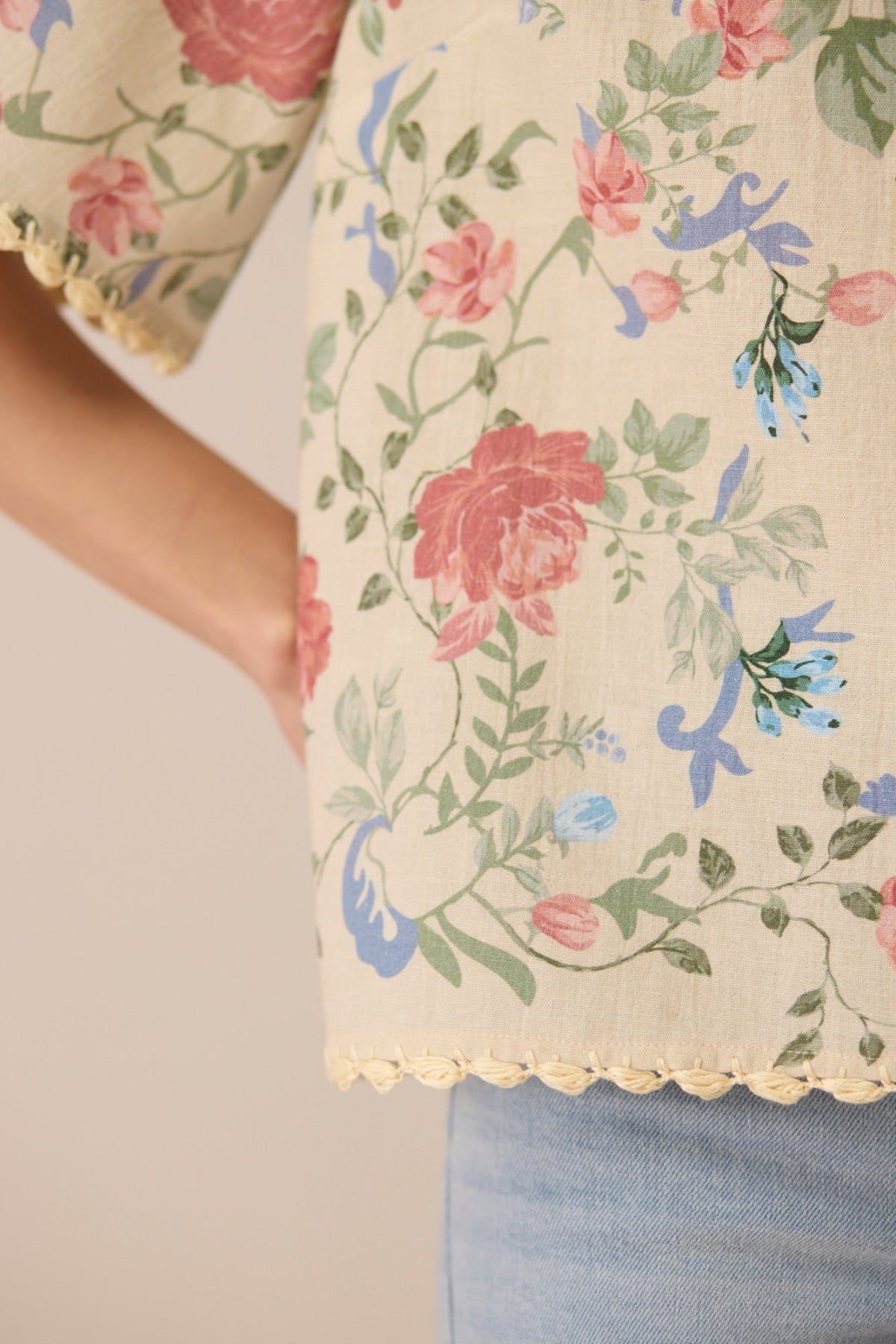 Floral patterned fabric with pink roses and green leaves on a beige background Calling June