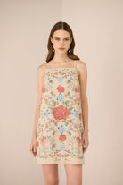 Woman wearing a floral dress against a beige background Calling June