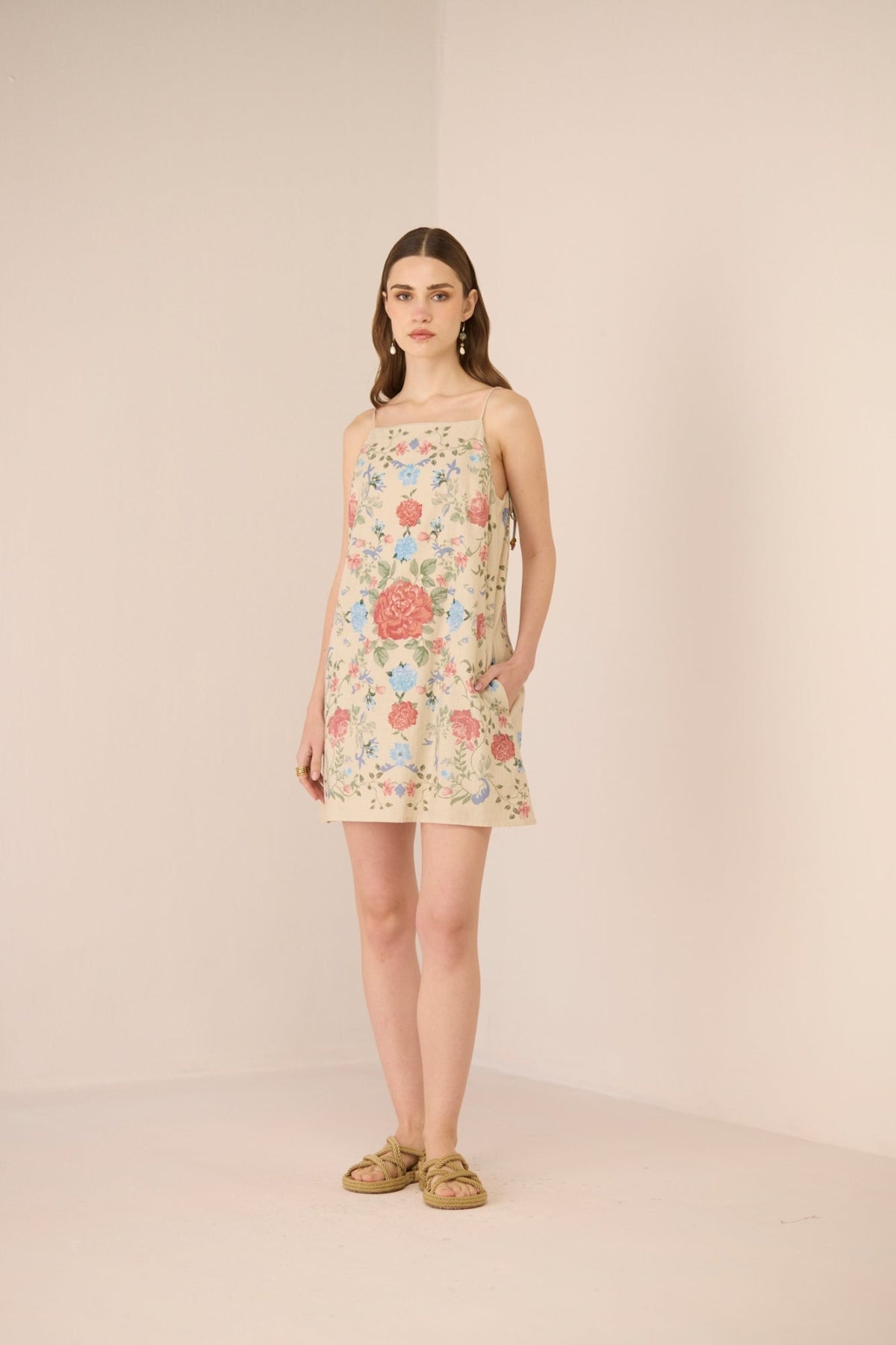 Woman wearing a floral dress against a plain background Calling June