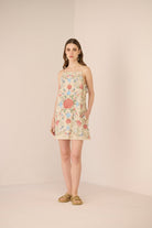 Woman wearing a floral dress against a plain background Calling June