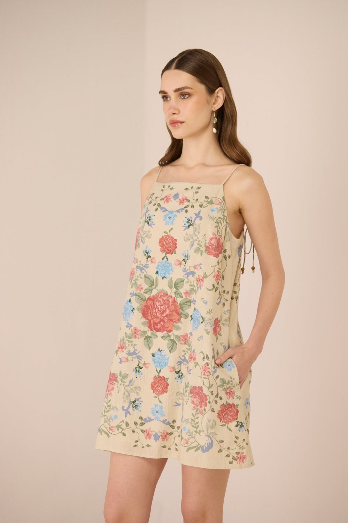 Woman wearing a floral dress against a beige background Calling June