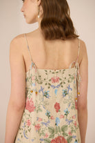 Woman wearing a floral dress with thin straps on a beige background Calling June