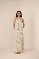 Woman wearing a strapless, long, patterned dress against a plain background Calling June