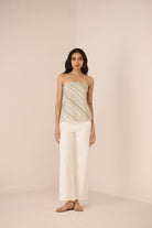 Woman wearing a strapless top and wide-leg pants on a plain background Calling June