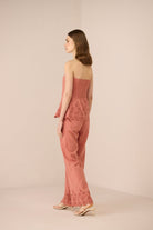 Woman wearing a pink lace outfit on a beige background Calling June