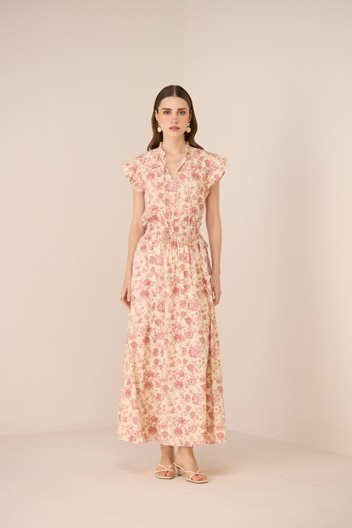 Woman wearing a floral dress on a beige background Calling June