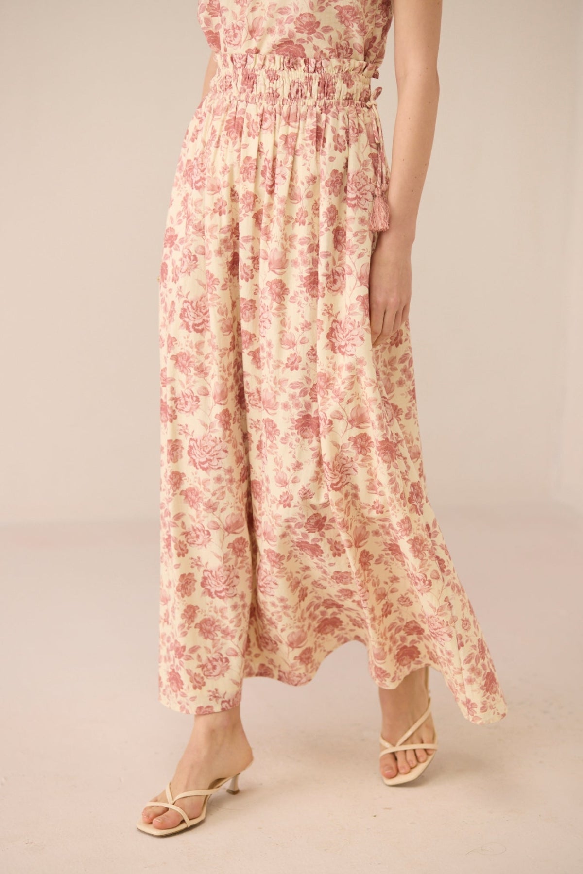 Woman wearing a floral dress on a plain background Calling June