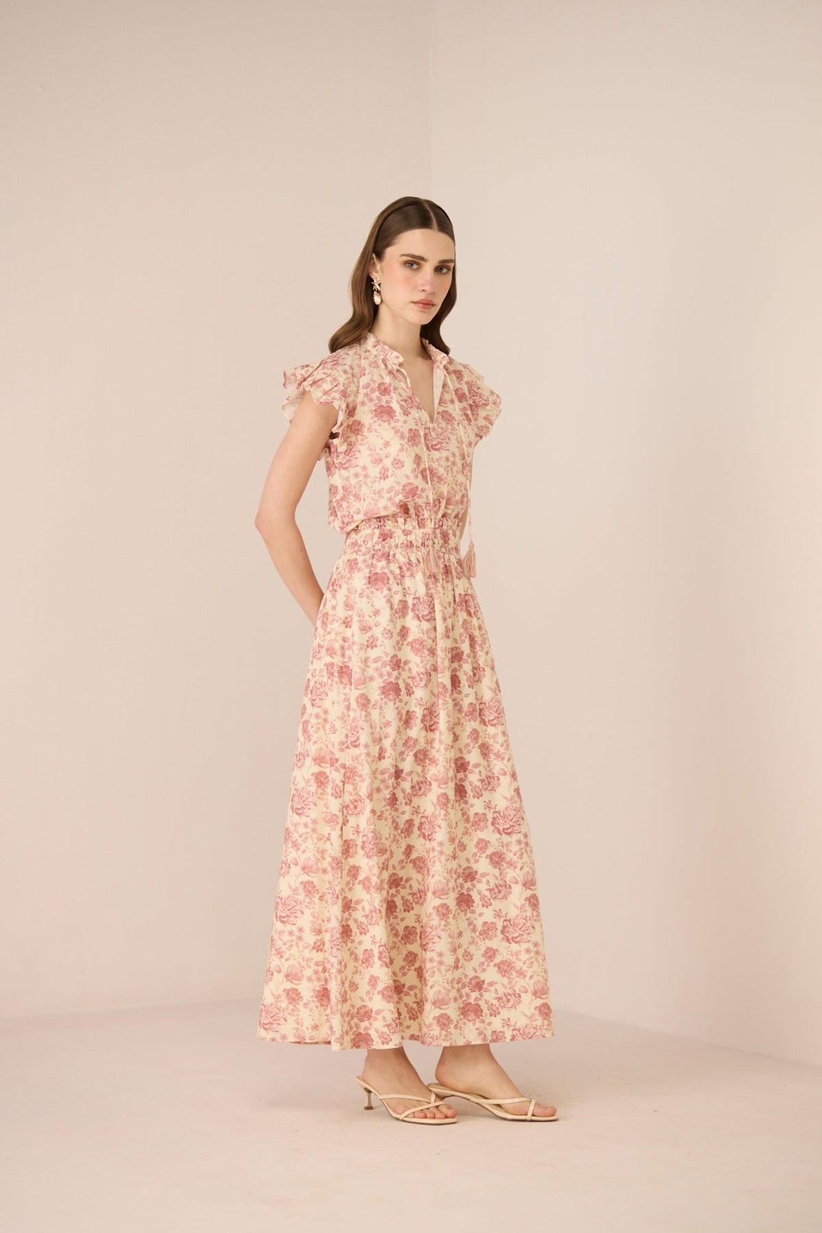 Woman wearing a floral dress on a beige background Calling June