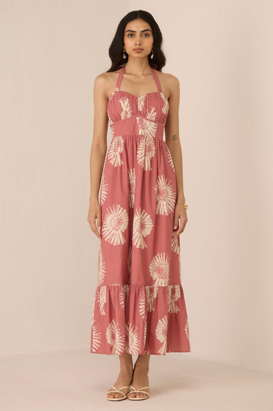 Woman wearing a pink floral dress against a beige background Calling June