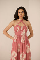 Woman wearing a pink floral dress against a beige background Calling June