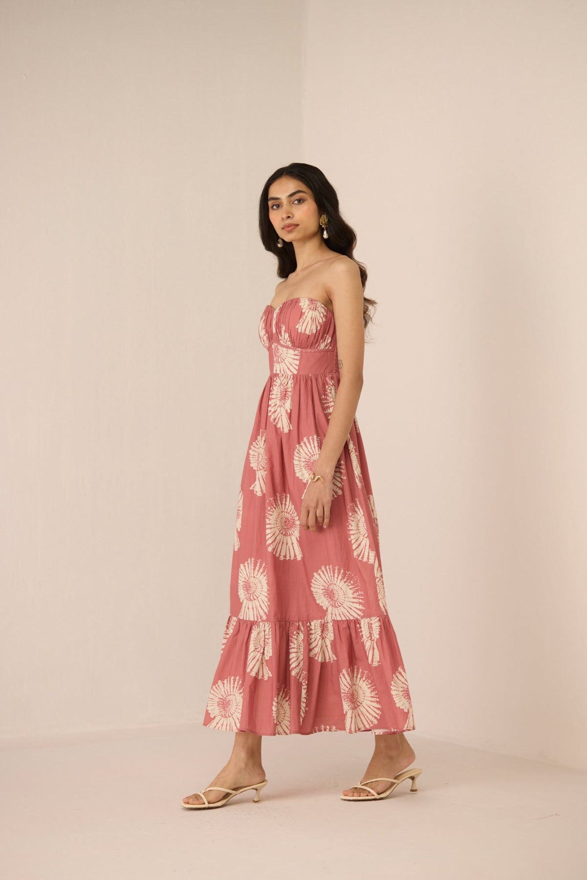 Woman wearing a pink floral dress against a plain background Calling June