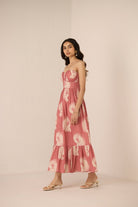 Woman wearing a pink floral dress against a plain background Calling June