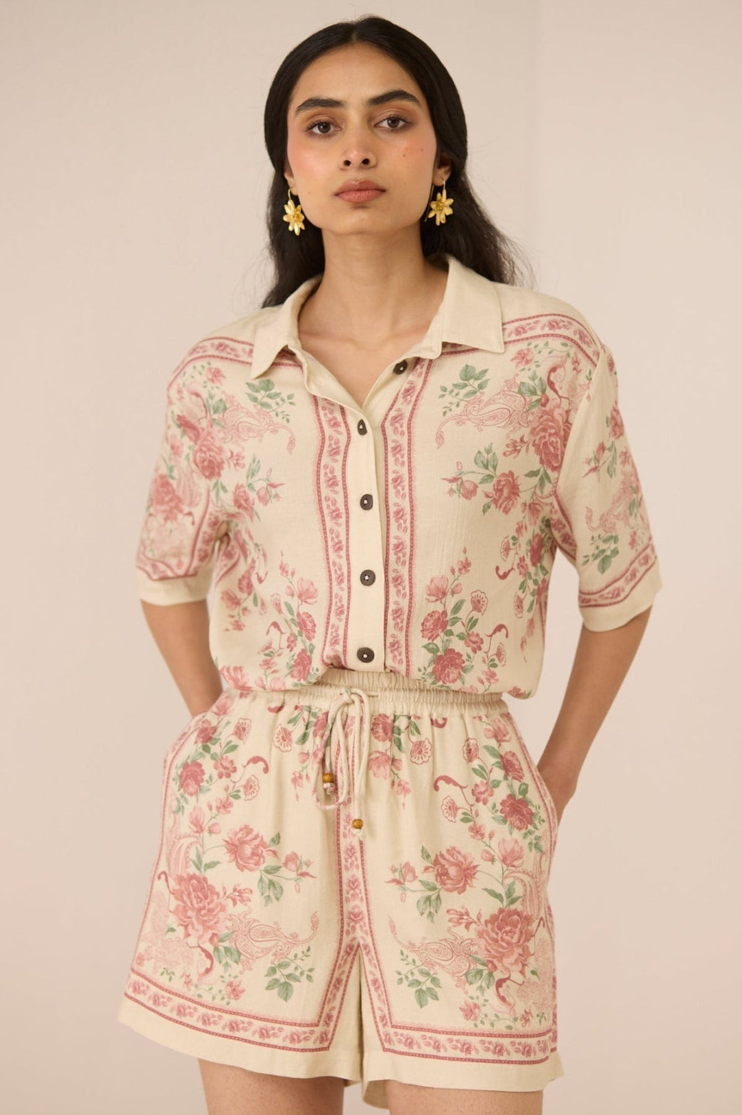 Woman wearing a floral romper against a plain background Calling June