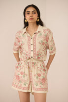Woman wearing a floral romper against a plain background Calling June