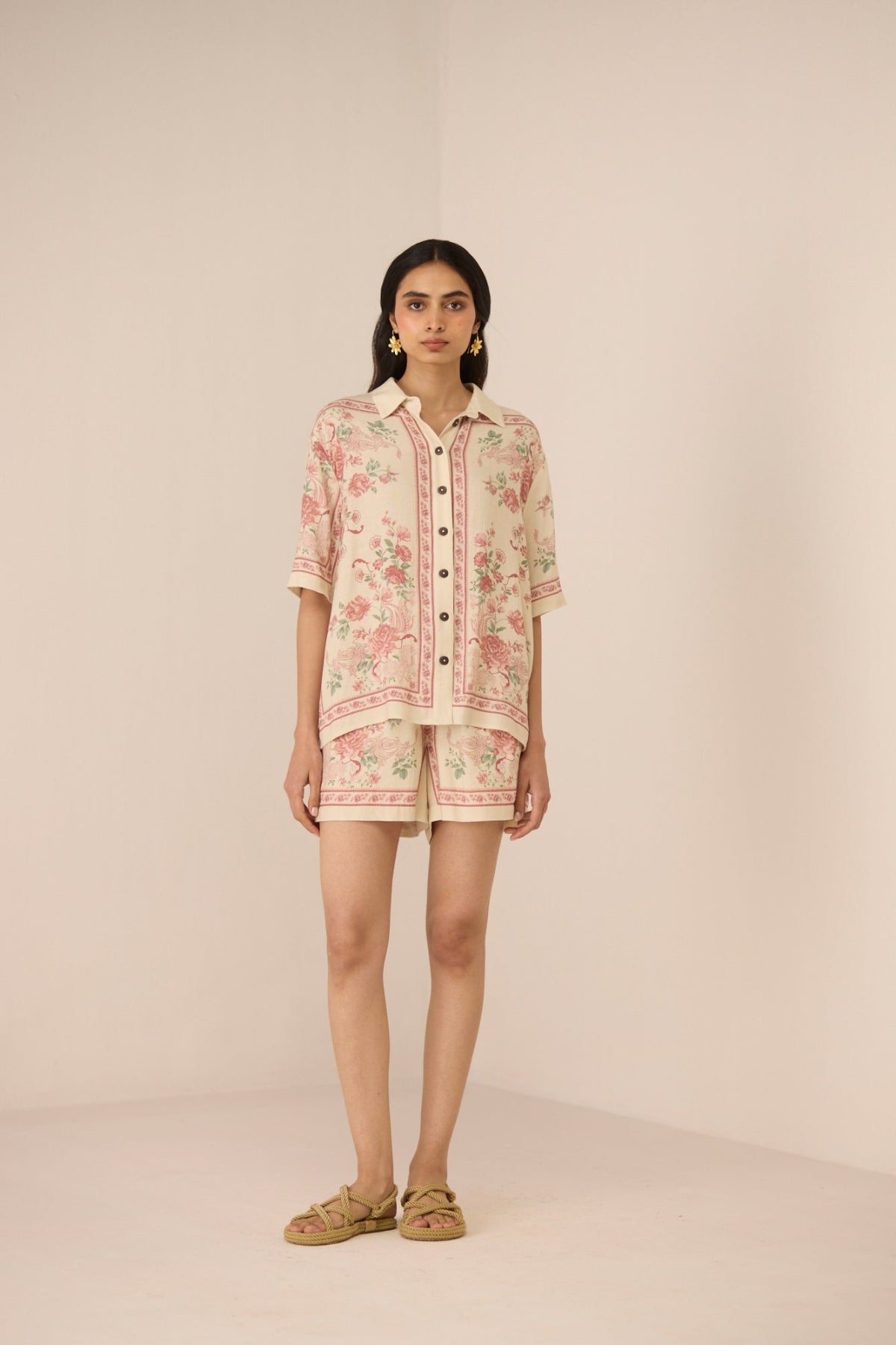 Woman wearing a floral outfit on a beige background Calling June