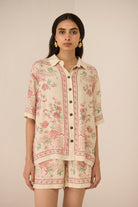 Woman wearing a floral outfit on a beige background Calling June