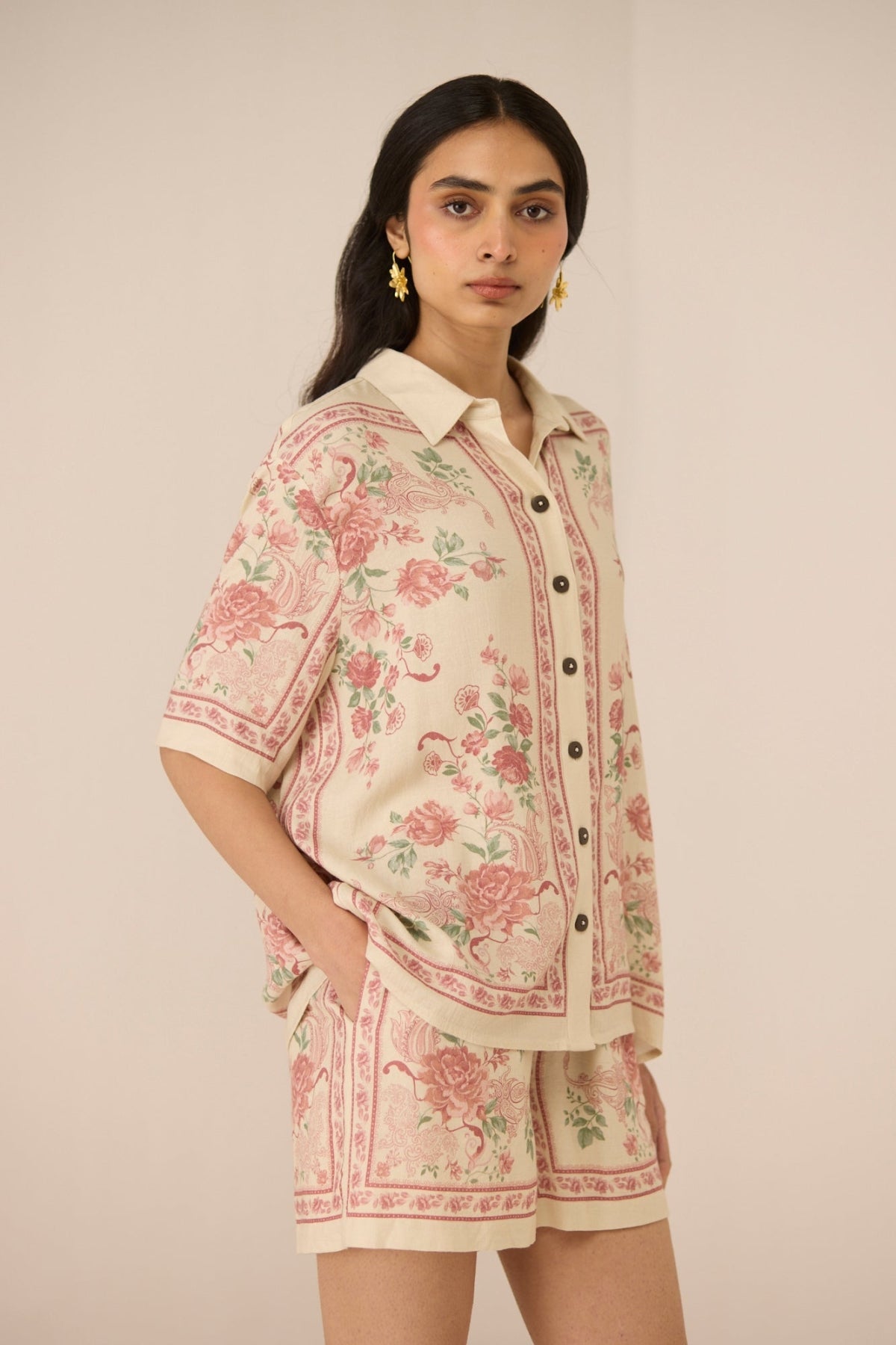Woman wearing a floral outfit on a beige background Calling June