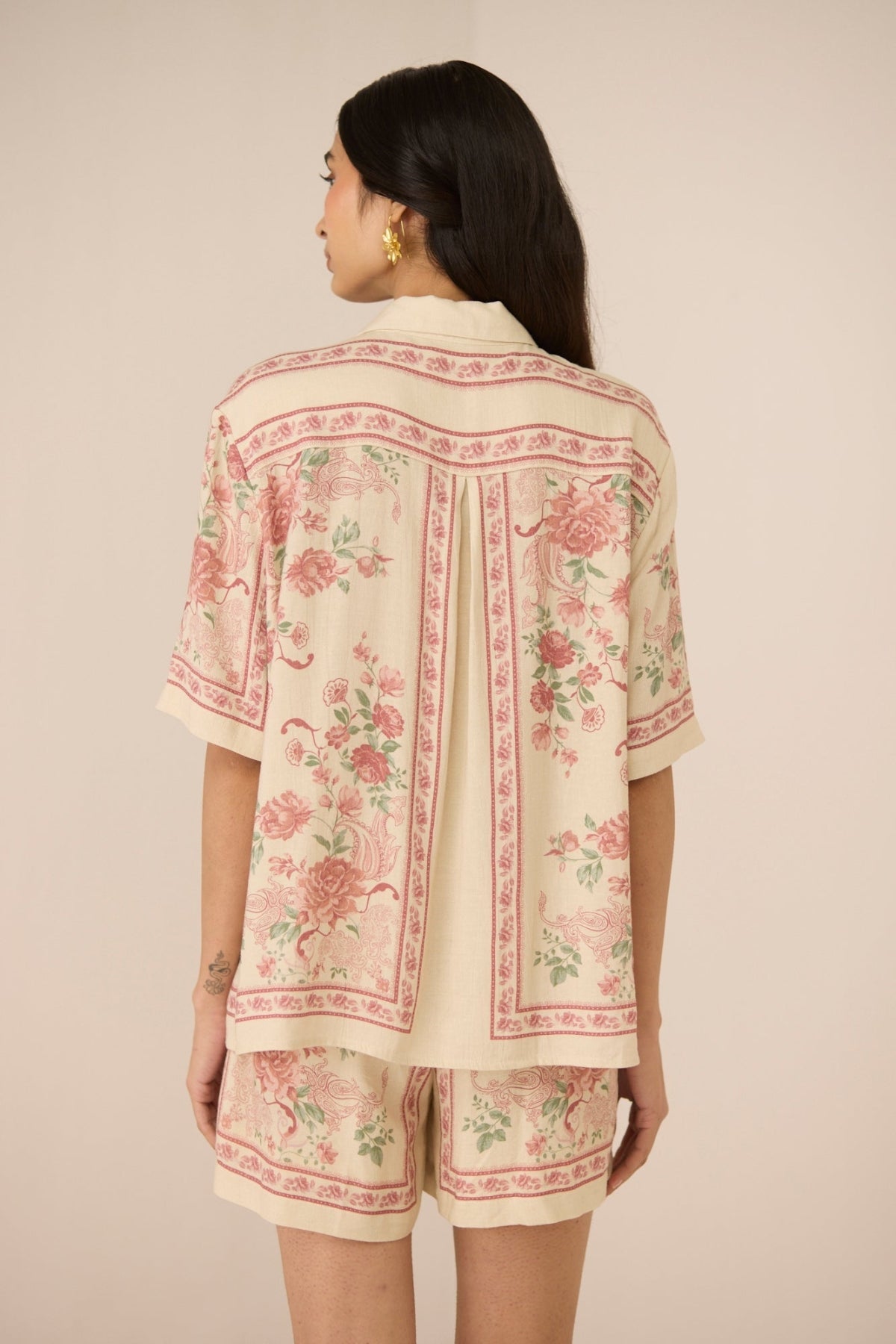 Woman wearing a floral patterned outfit on a beige background Calling June