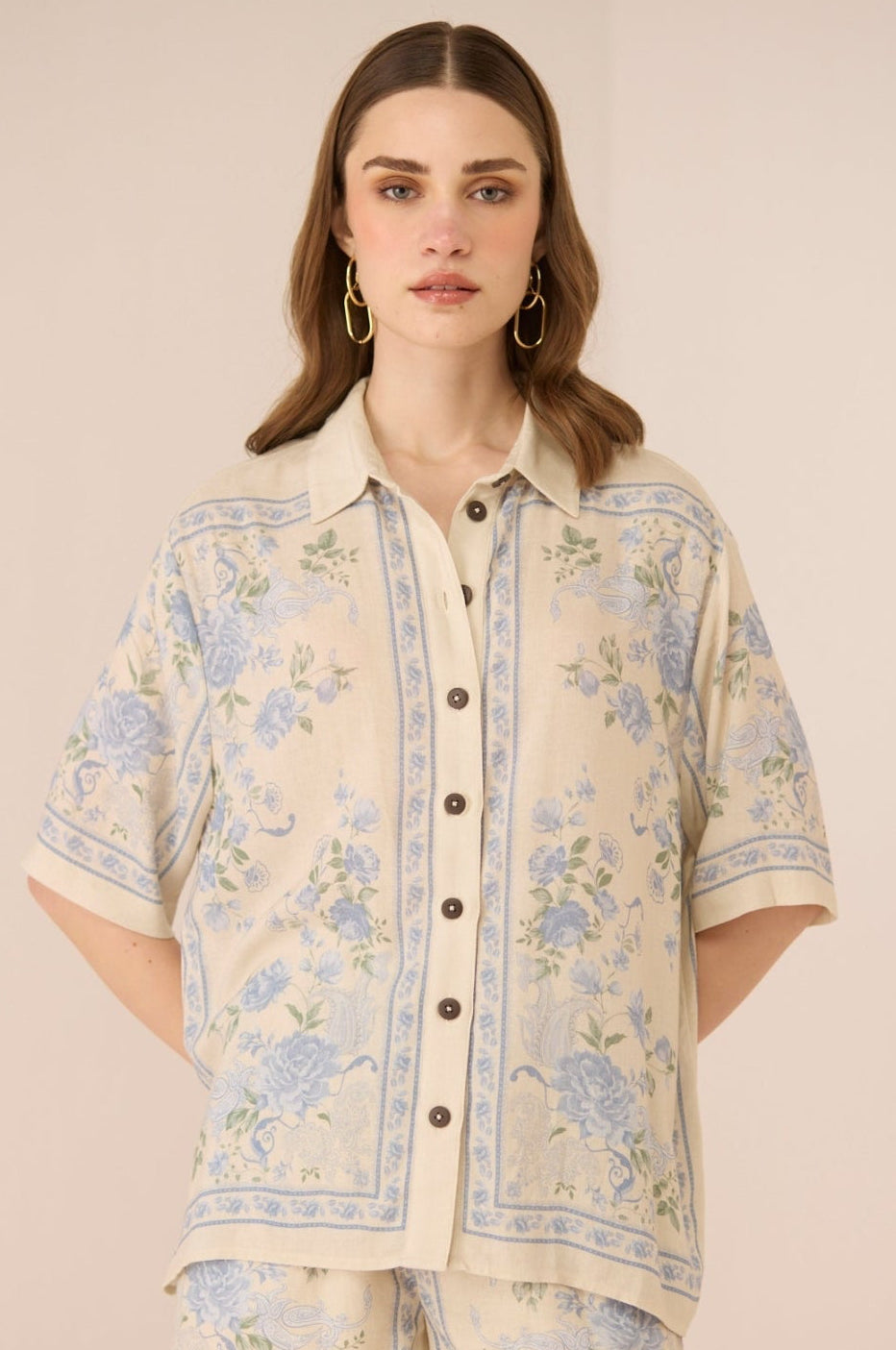 Woman wearing a floral patterned outfit on a beige background Calling June