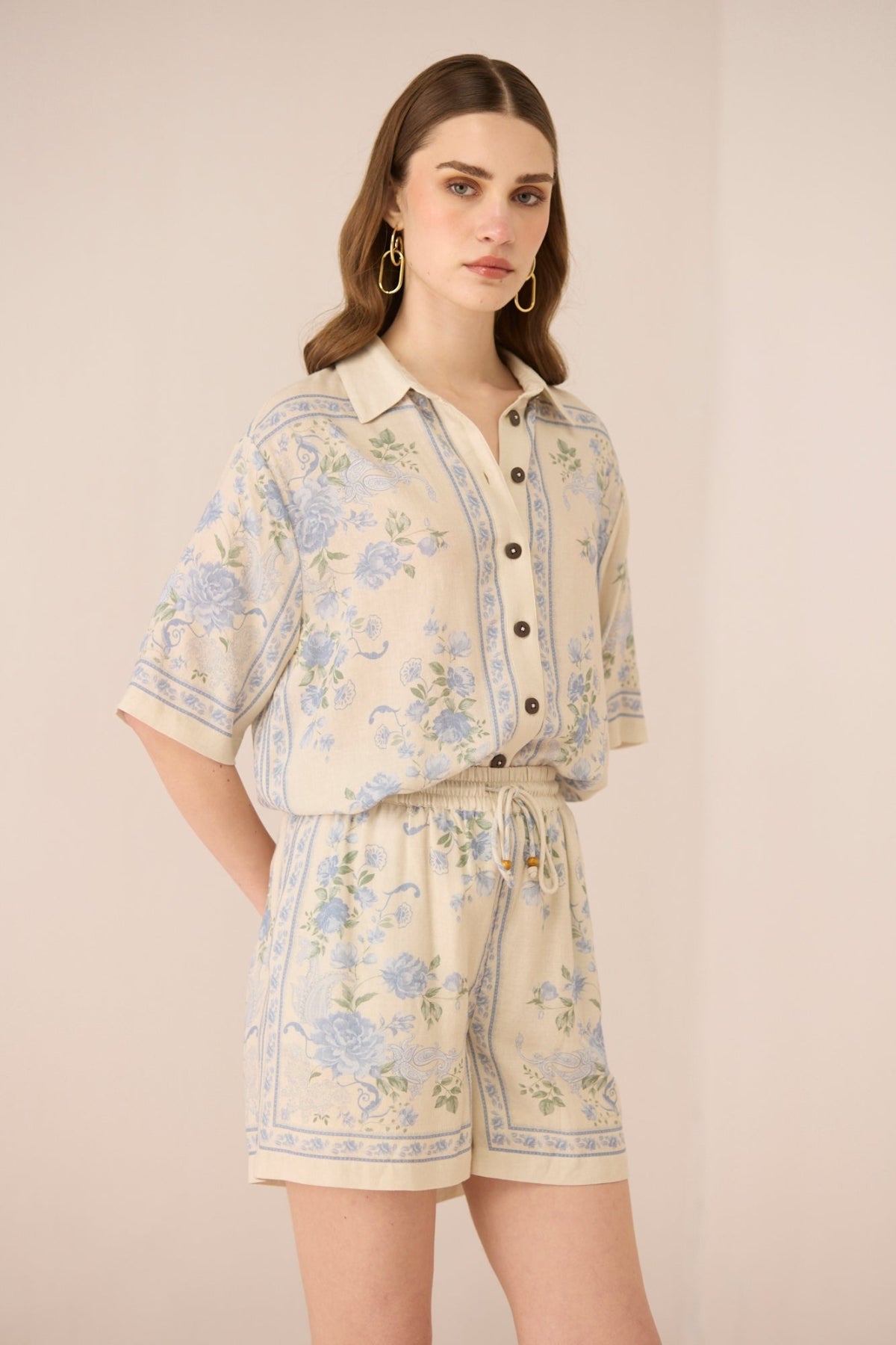 Woman wearing a floral outfit on a beige background Calling June