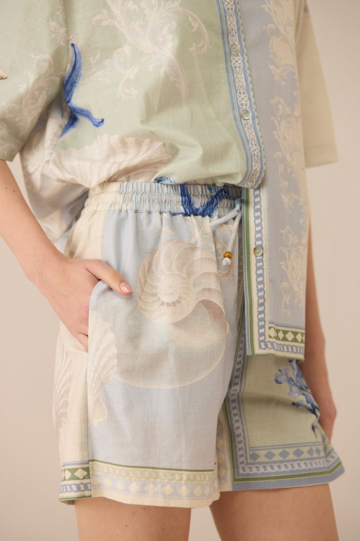 Traditional outfit with embroidered top and shorts on a plain background Calling June