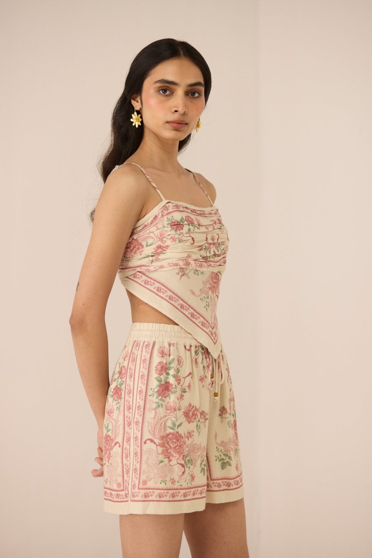 Woman wearing a floral two-piece outfit on a beige background Calling June